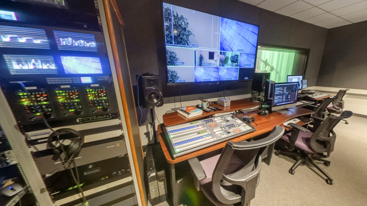 The TV studio features an HD digital production switcher with 2 ME's Broadcast graphics system, live HD streaming capability, three professional Hitachi HD broadcast cameras with Fujinon lenses, teleprompters, green screen keying, and a real news set from KTLA.